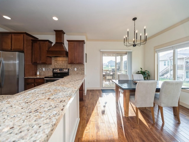 kitchen with crown molding, a chandelier, appliances with stainless steel finishes, custom range hood, and dark wood-style flooring
