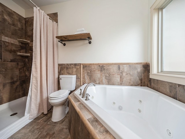 bathroom with toilet, a tub with jets, and a stall shower
