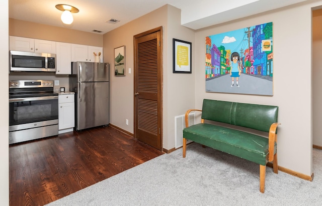 5322 Ingersoll Ave Unit B5, Des Moines, IA 50312 - kitchen featuring stainless steel appliances, white cabinetry, dark carpet, and dark wood finished floors