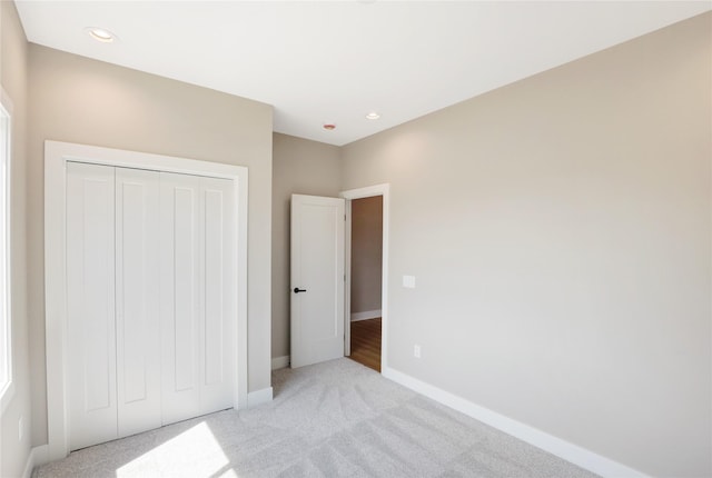 304 13th St NW, Bondurant, IA 50035 - unfurnished bedroom with light carpet, baseboards, a closet, and recessed lighting