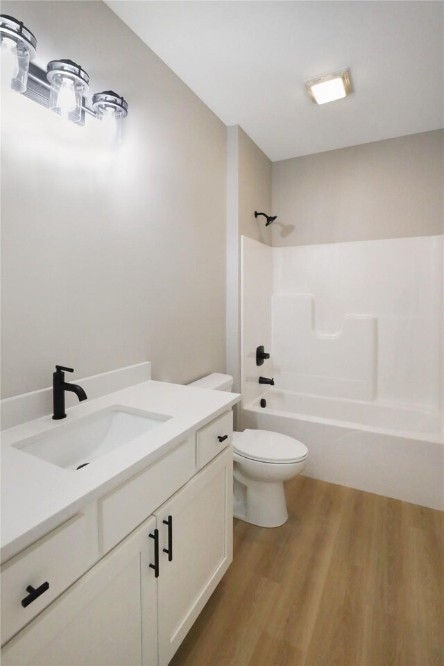 304 13th St NW, Bondurant, IA 50035 - bathroom featuring shower / bath combination, toilet, wood finished floors, and vanity
