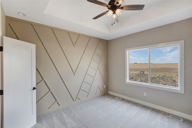 304 13th St NW, Bondurant, IA 50035 - empty room with carpet flooring, a raised ceiling, a ceiling fan, and baseboards