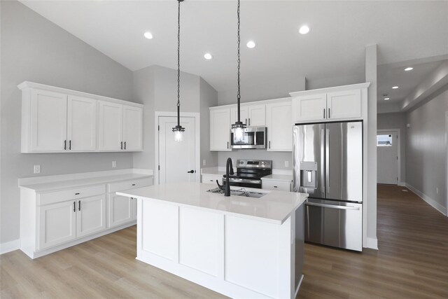 304 13th St NW, Bondurant, IA 50035 - kitchen with appliances with stainless steel finishes, a sink, lofted ceiling, light wood finished floors, and white cabinetry