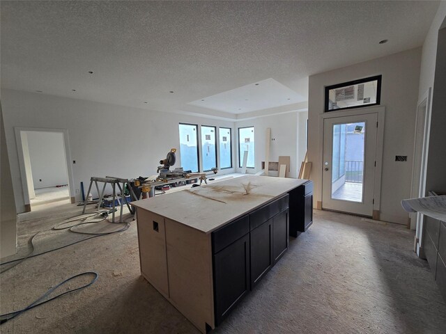 4611 Centennial Blvd, Urbandale, IA 50323 - kitchen featuring open floor plan, healthy amount of natural light, a textured ceiling, a kitchen island, and light countertops