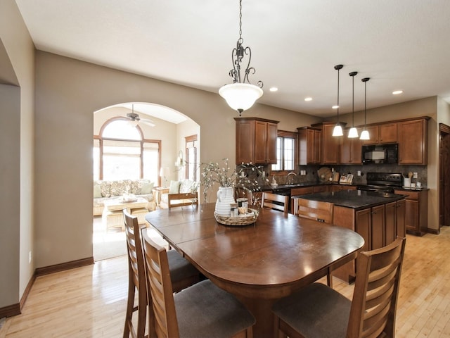 1835 SE Hillside Dr, Ankeny, IA 50021 - dining room with arched walkways, light wood-style flooring, recessed lighting, and ceiling fan