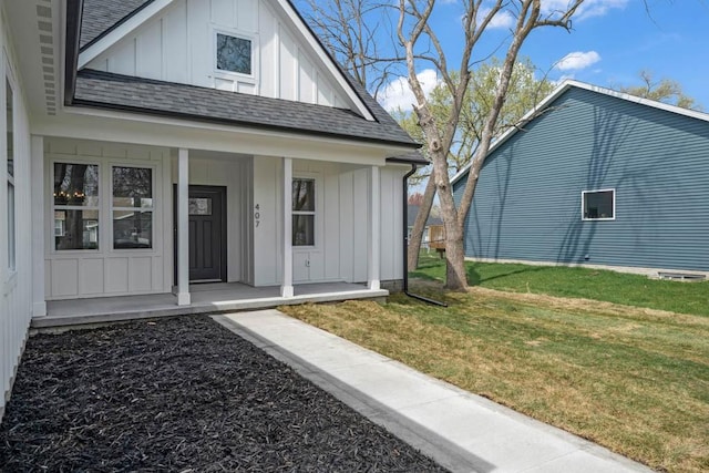view of front of property with a front yard, board and batten siding, a shingled roof, and covered porch