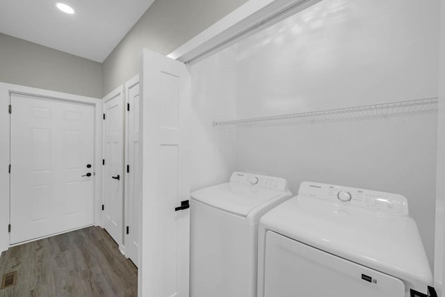 clothes washing area featuring visible vents, wood finished floors, independent washer and dryer, and laundry area