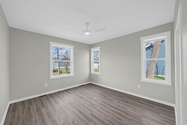 unfurnished room featuring wood finished floors, baseboards, and ceiling fan