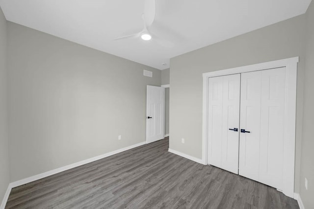 unfurnished bedroom with baseboards, wood finished floors, visible vents, and a closet