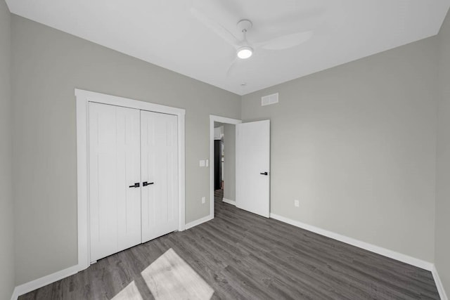unfurnished bedroom with wood finished floors, visible vents, a ceiling fan, a closet, and baseboards