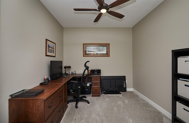 carpeted office with baseboards and ceiling fan
