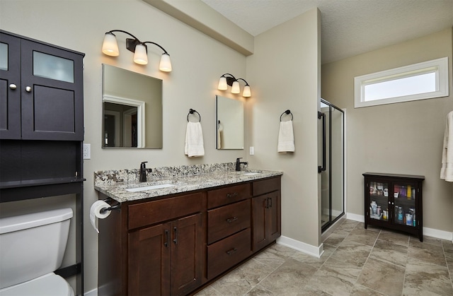 full bathroom featuring a shower stall, toilet, a sink, and baseboards