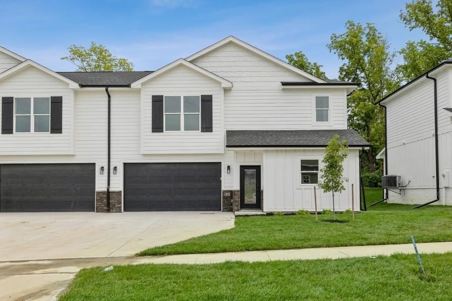 1010 Ledgestone Ct, Polk City, IA 50226 - view of front facade featuring concrete driveway, board and batten siding, an attached garage, a front yard, and roof with shingles