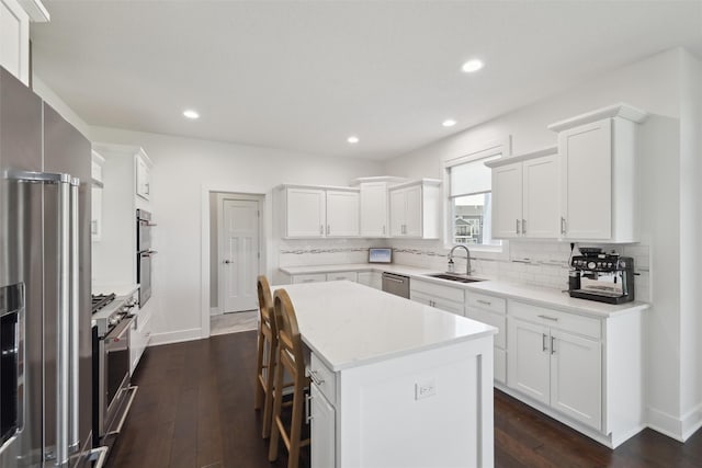 3667 NW 165th St, Clive, IA 50325 - kitchen with a sink, stainless steel appliances, decorative backsplash, dark wood-style floors, and a kitchen island