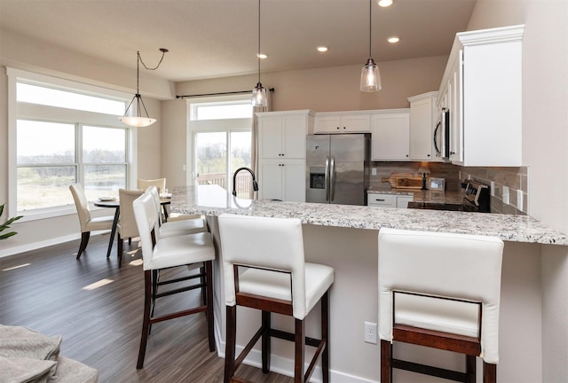 172 Crossroads Dr, Des Moines, IA 50320 - kitchen with stainless steel appliances, dark wood-style flooring, white cabinets, plenty of natural light, and recessed lighting