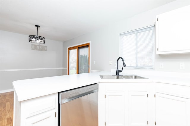 kitchen with light countertops, dishwasher, a sink, a peninsula, and white cabinetry