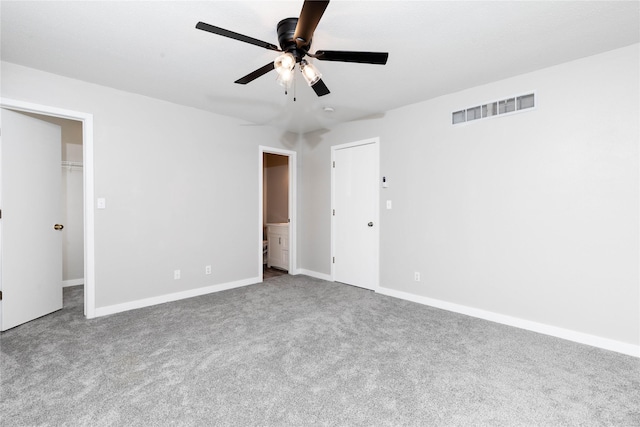 unfurnished bedroom with carpet flooring, ensuite bathroom, baseboards, visible vents, and a spacious closet