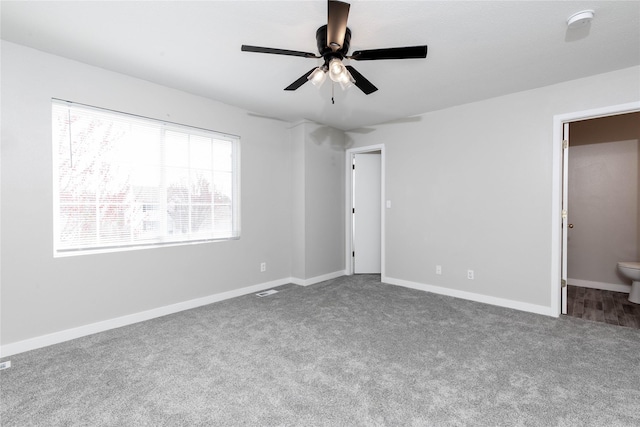 unfurnished bedroom featuring a ceiling fan, baseboards, carpet, and ensuite bathroom