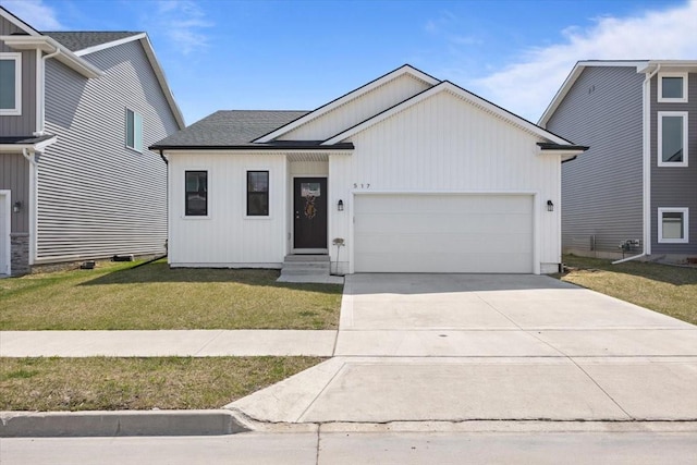view of front of property featuring a shingled roof, a front lawn, entry steps, an attached garage, and driveway