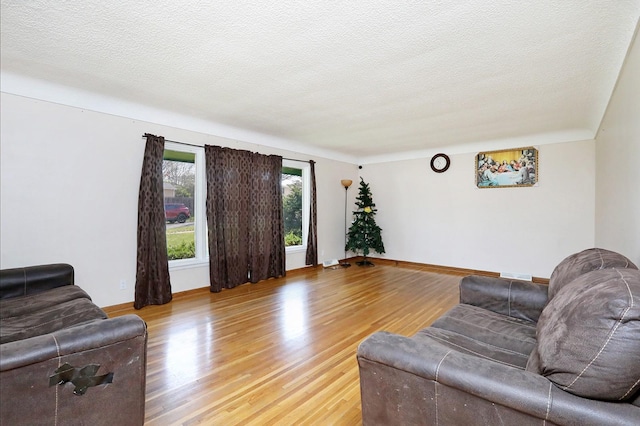 7422 Oak Brook Dr, Urbandale, IA 50322 - living room with light wood-type flooring, baseboards, a textured ceiling, and visible vents