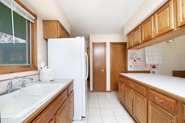 7422 Oak Brook Dr, Urbandale, IA 50322 - kitchen featuring light countertops, freestanding refrigerator, a sink, and light tile patterned floors