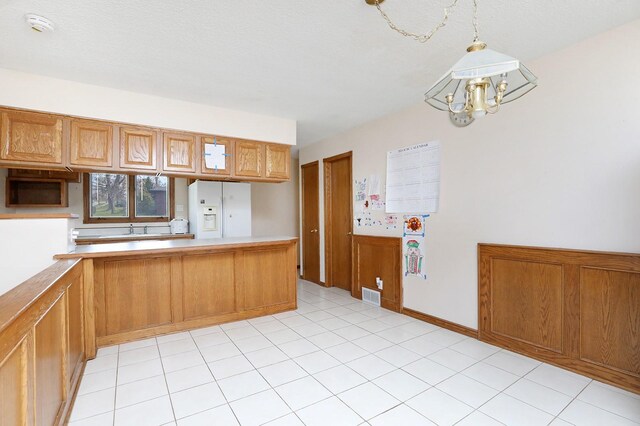 7422 Oak Brook Dr, Urbandale, IA 50322 - kitchen featuring white refrigerator with ice dispenser, brown cabinets, an inviting chandelier, light countertops, and decorative light fixtures