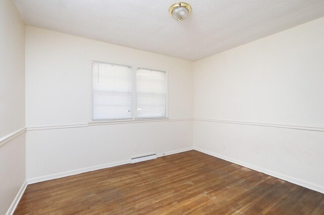 7422 Oak Brook Dr, Urbandale, IA 50322 - spare room with baseboard heating, baseboards, and wood finished floors