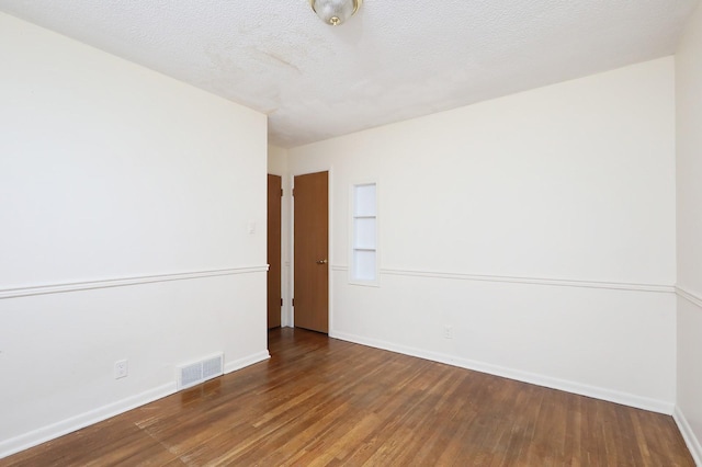 7422 Oak Brook Dr, Urbandale, IA 50322 - empty room featuring baseboards, wood finished floors, visible vents, and a textured ceiling
