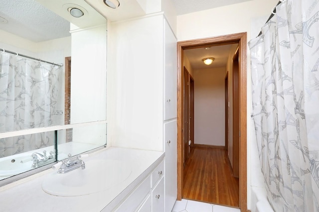 7422 Oak Brook Dr, Urbandale, IA 50322 - full bathroom with a shower with shower curtain, a textured ceiling, and vanity