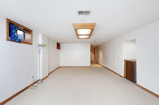 7422 Oak Brook Dr, Urbandale, IA 50322 - finished below grade area featuring light carpet, visible vents, and baseboards