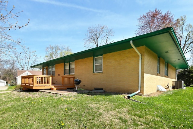 7422 Oak Brook Dr, Urbandale, IA 50322 - back of house featuring a lawn, a wooden deck, brick siding, and central air condition unit