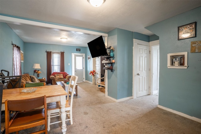 carpeted dining room with baseboards