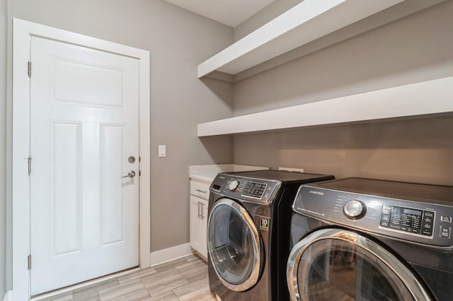 laundry room featuring baseboards, washer and clothes dryer, and cabinet space