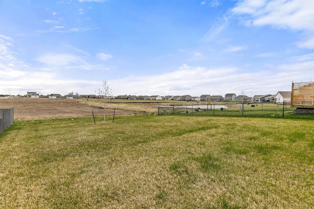 view of yard featuring fence and a residential view