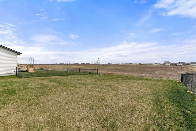 view of yard with fence and a rural view