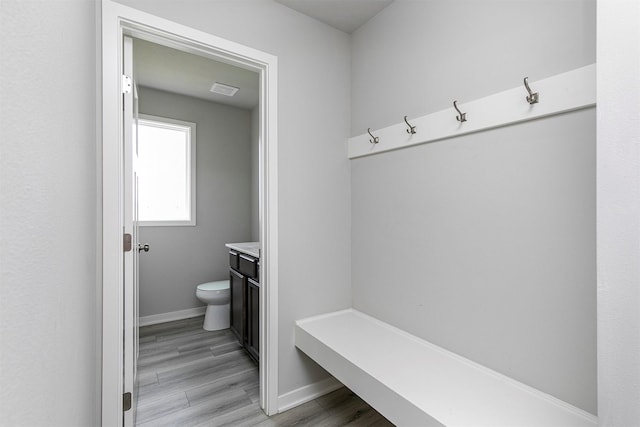 mudroom featuring light wood-type flooring, visible vents, and baseboards