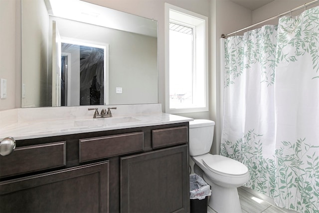 bathroom with toilet, vanity, and a shower with shower curtain