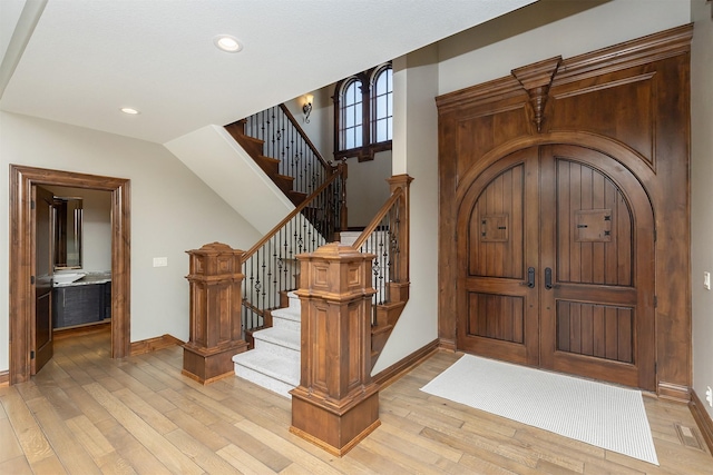 foyer entrance with recessed lighting, light wood-style floors, stairs, and baseboards
