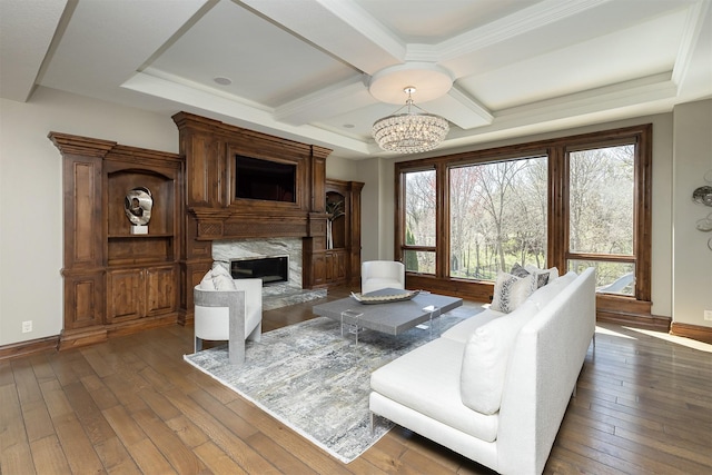 living room featuring a fireplace, dark wood finished floors, plenty of natural light, and a notable chandelier