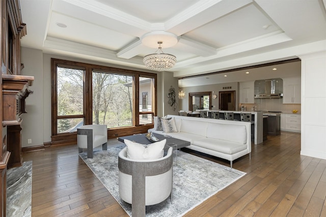 living area featuring hardwood / wood-style flooring, coffered ceiling, and a chandelier