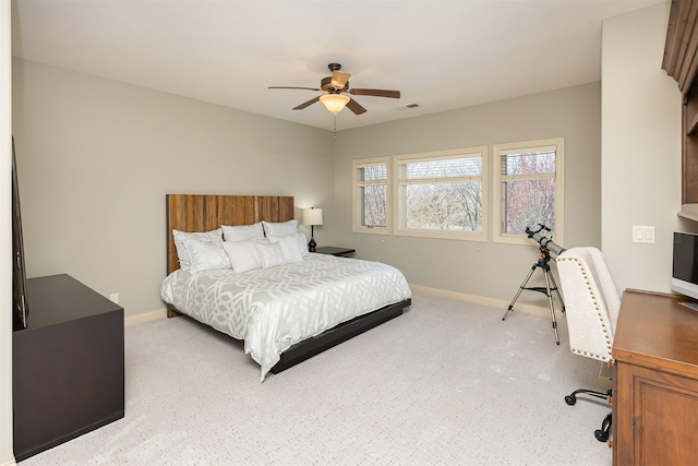 bedroom with baseboards, visible vents, a ceiling fan, and light colored carpet