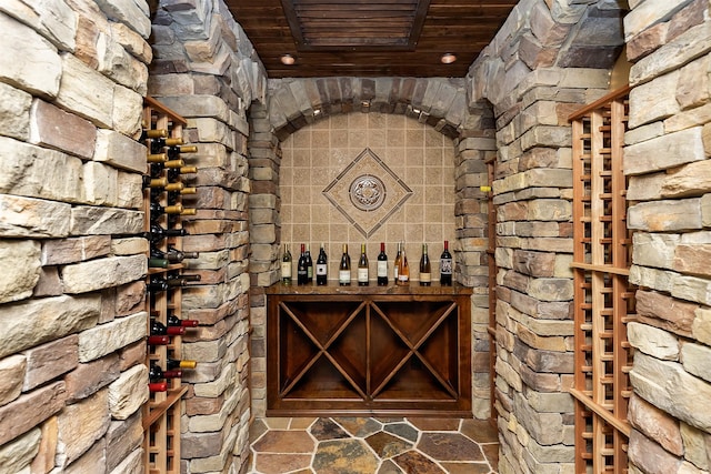 wine area with wooden ceiling and stone finish flooring