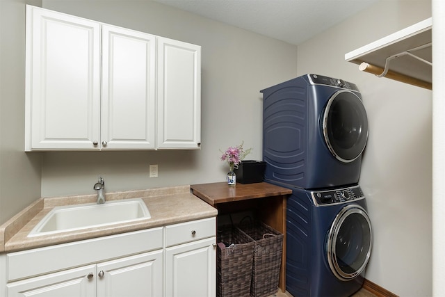 clothes washing area with cabinet space, stacked washer / dryer, and a sink
