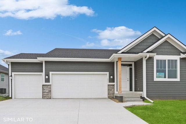 4316 NE 8th St, Ankeny, IA 50021 - view of front of property with an attached garage, stone siding, central AC unit, and driveway