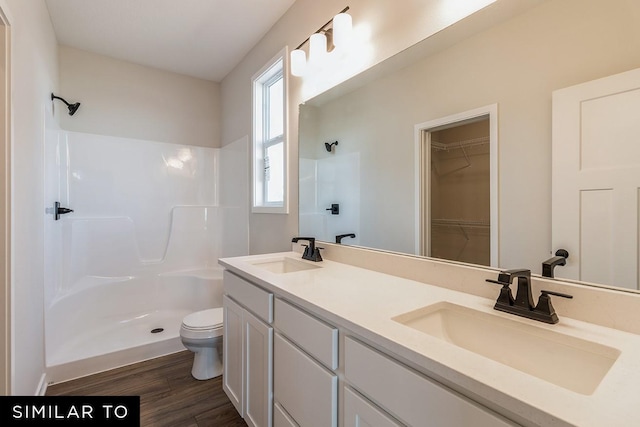 4316 NE 8th St, Ankeny, IA 50021 - full bathroom featuring wood finished floors, a sink, a shower, and toilet