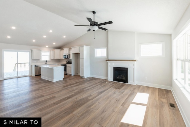 4412 NE 8th St, Ankeny, IA 50021 - unfurnished living room with visible vents, light wood-style flooring, ceiling fan, and vaulted ceiling