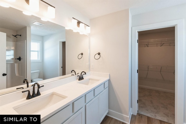 4412 NE 8th St, Ankeny, IA 50021 - full bathroom with wood finished floors, a sink, a shower, and toilet