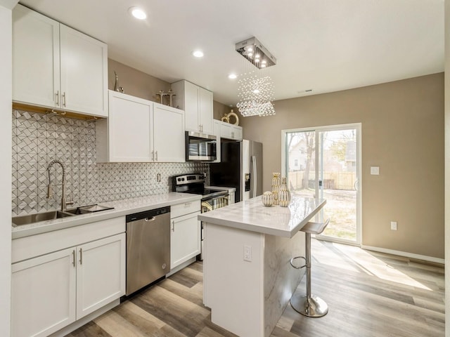 1710 Forest Ave, Des Moines, IA 50314 - kitchen featuring white cabinetry, appliances with stainless steel finishes, decorative backsplash, and a sink