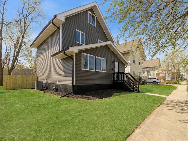 1710 Forest Ave, Des Moines, IA 50314 - view of front of house featuring central AC, fence, and a front yard
