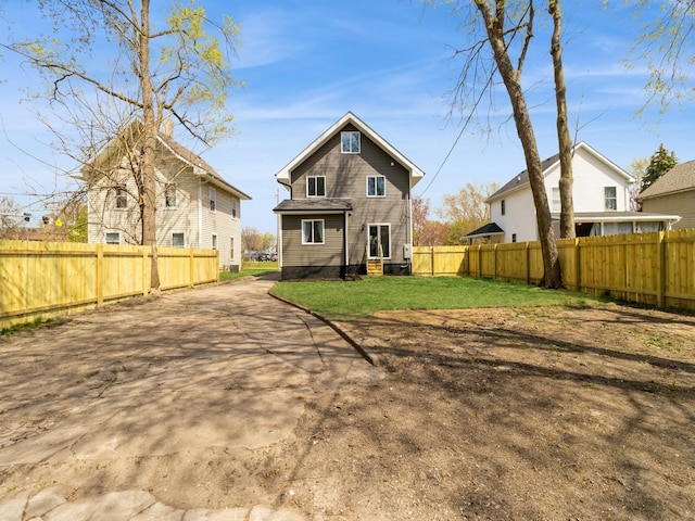 1710 Forest Ave, Des Moines, IA 50314 - back of house with a fenced backyard and a lawn